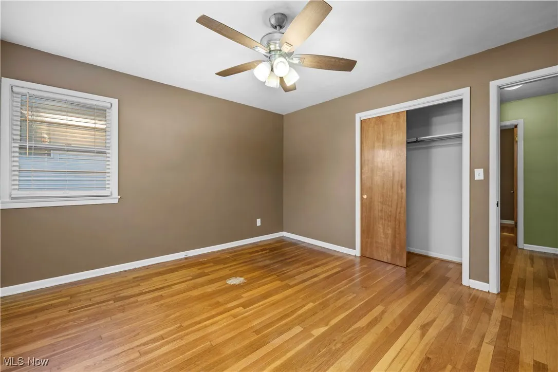 Unfurnished bedroom featuring light wood-style floors, ceiling fan, and a closet