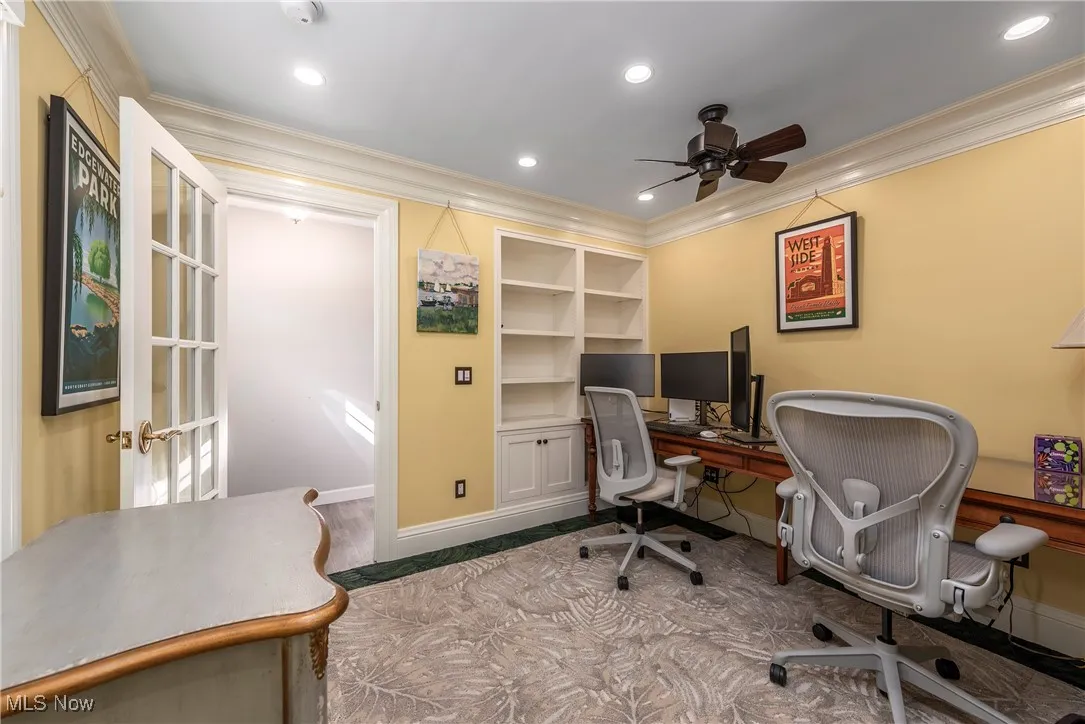 Office space featuring built in shelves, ceiling fan, crown molding, and recessed lighting