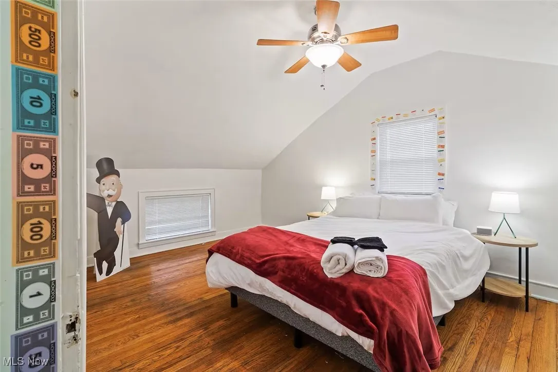 Bedroom with lofted ceiling, wood finished floors, and ceiling fan