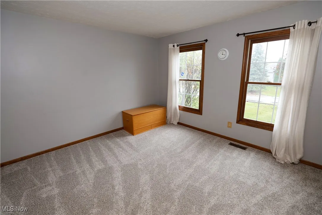 Spare room featuring light carpet and a textured ceiling