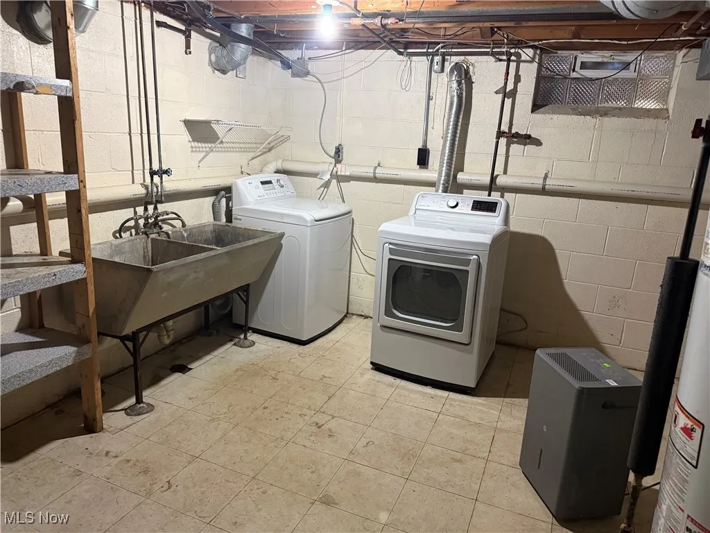 Washroom featuring water heater and separate washer and dryer
