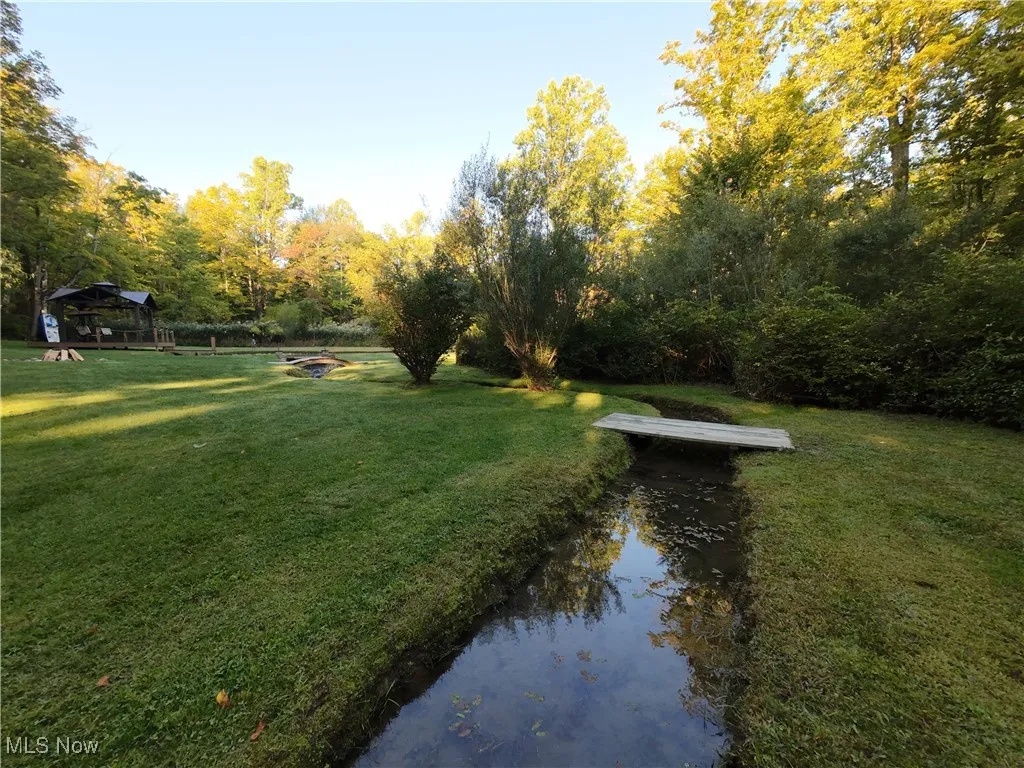 View of grassy yard with a gazebo and a fire pit