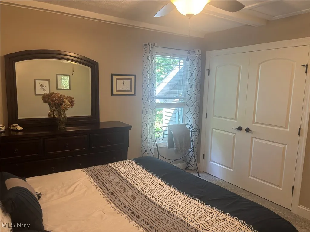 Carpeted bedroom featuring a closet and ceiling fan