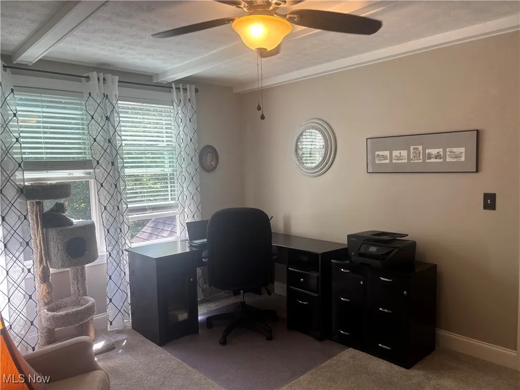 Office featuring beam ceiling, carpet, a ceiling fan, and a textured ceiling