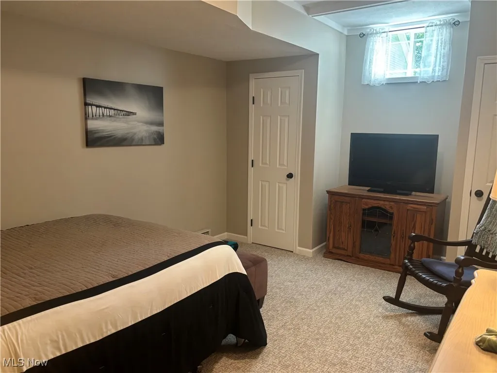 Bedroom with light colored carpet and baseboards