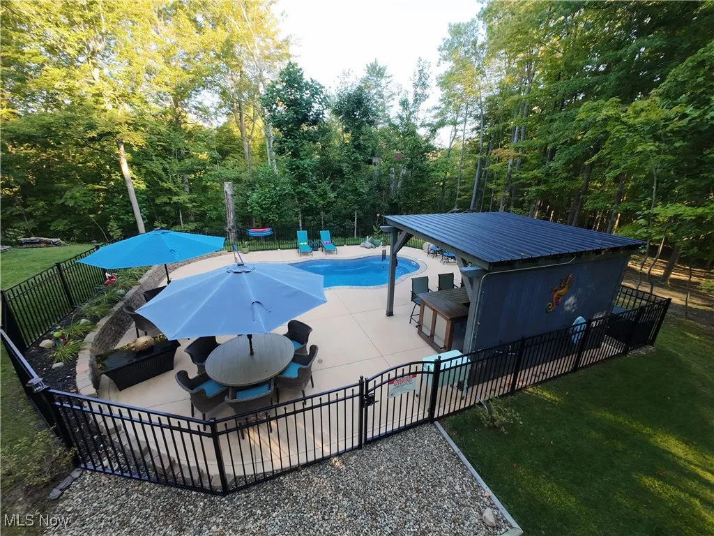 View of pool featuring a fenced backyard, a patio, outdoor dining area, and view of scattered trees