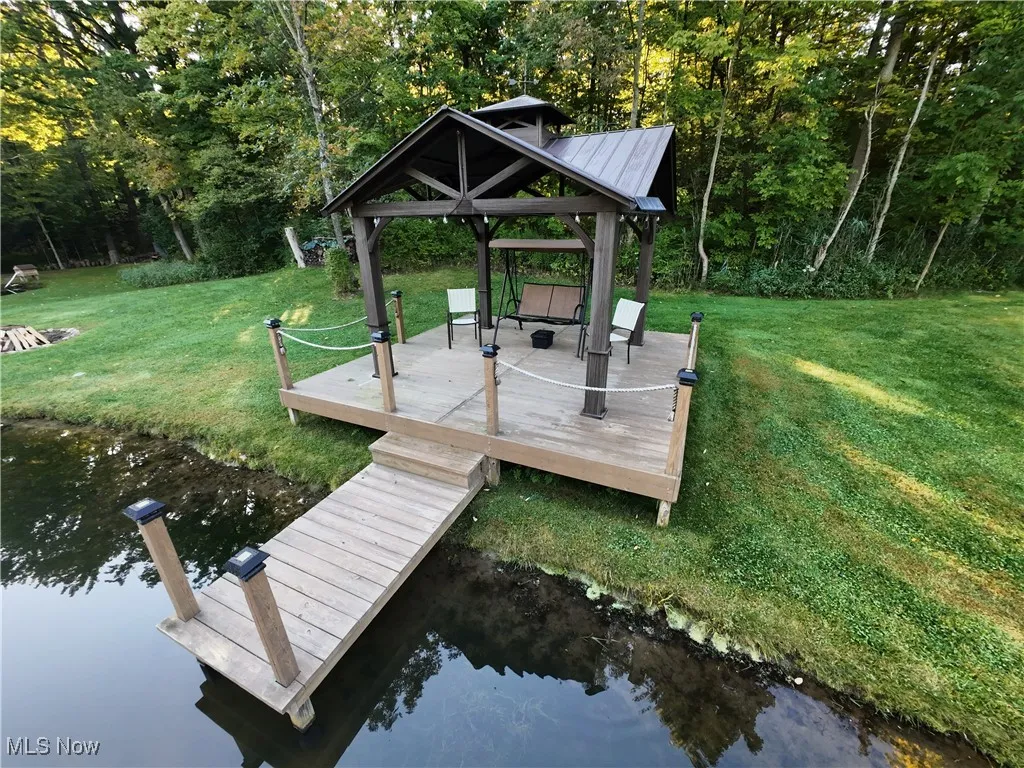 Dock area featuring a water view and a yard
