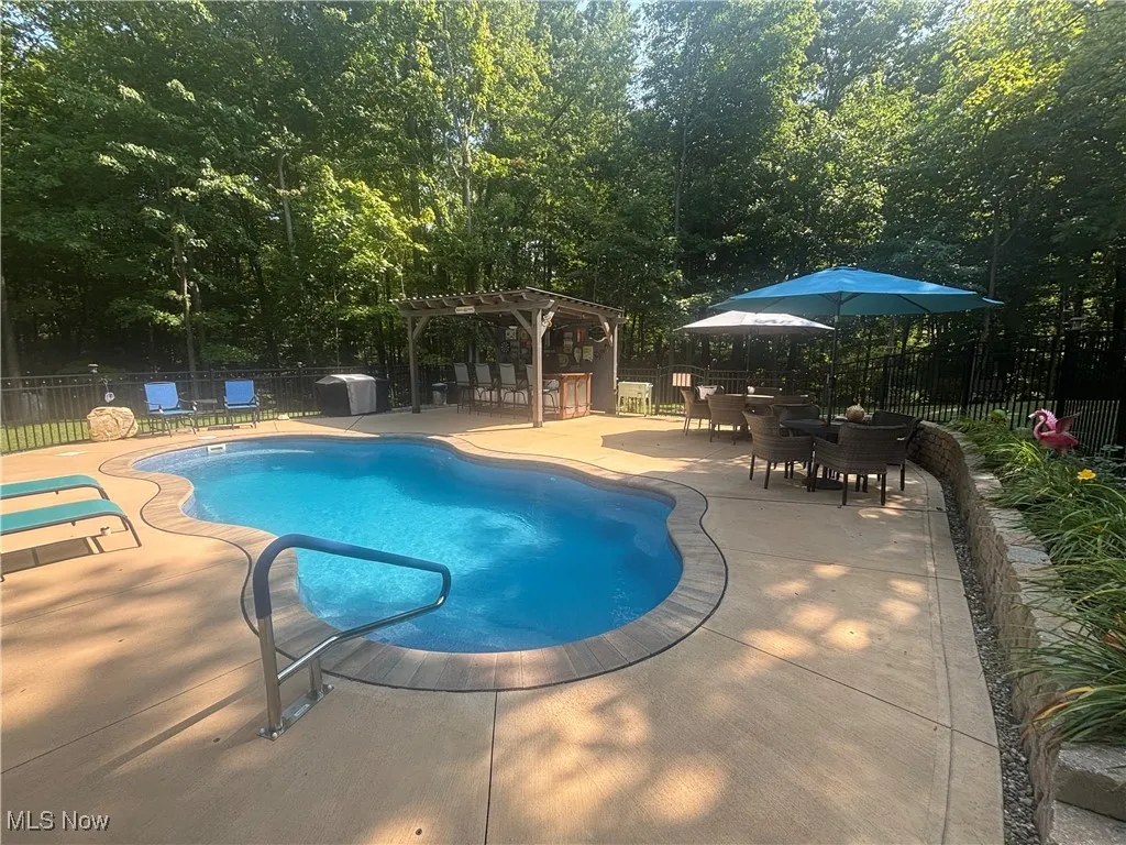 View of swimming pool with a patio, a pergola, and outdoor dining area
