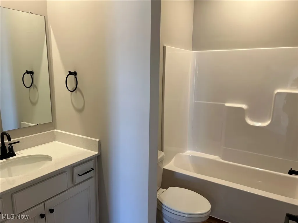 Full bath featuring vanity and washtub / shower combination