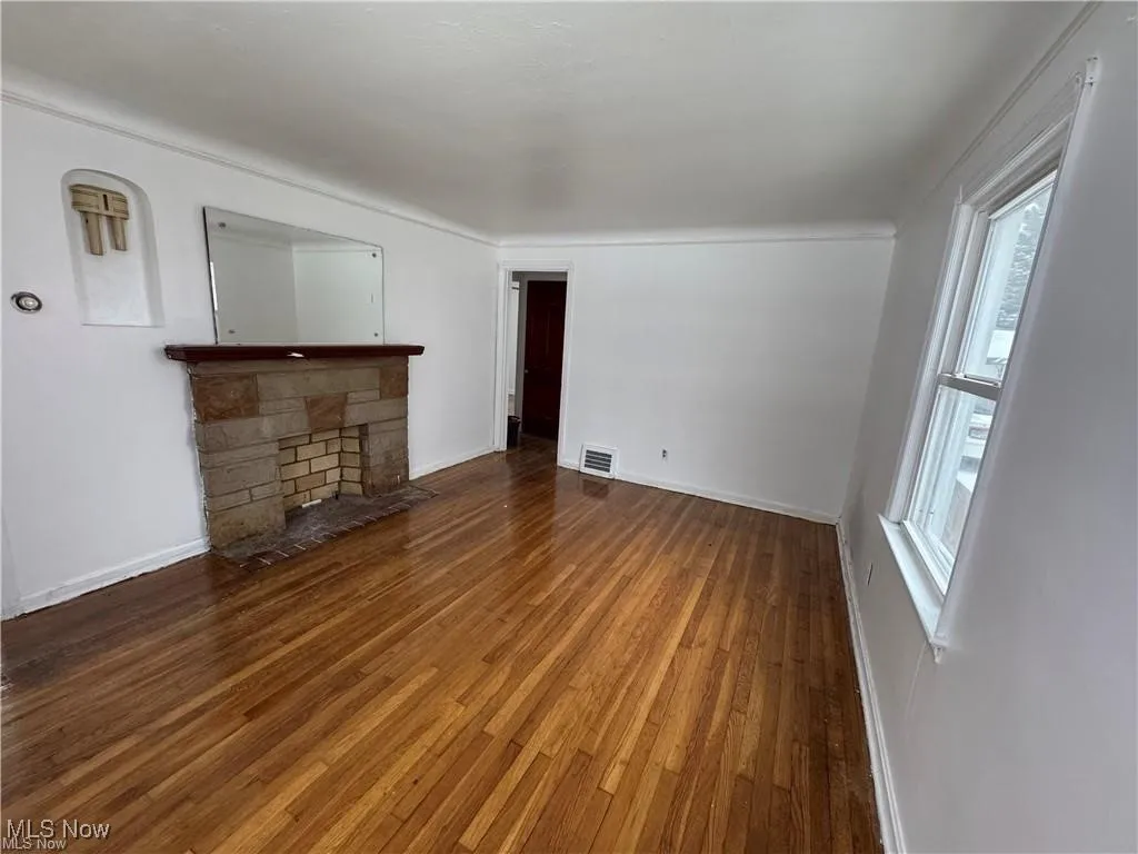 Unfurnished living room with hardwood / wood-style floors and a fireplace