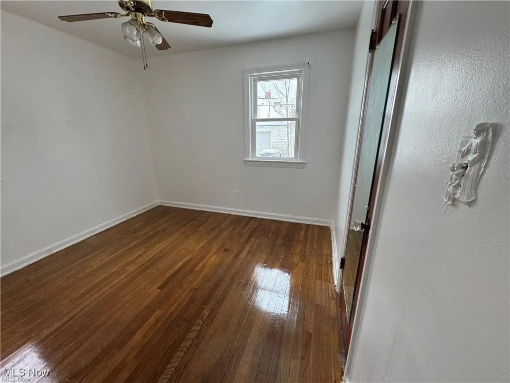 Unfurnished bedroom with dark wood-style flooring and a ceiling fan