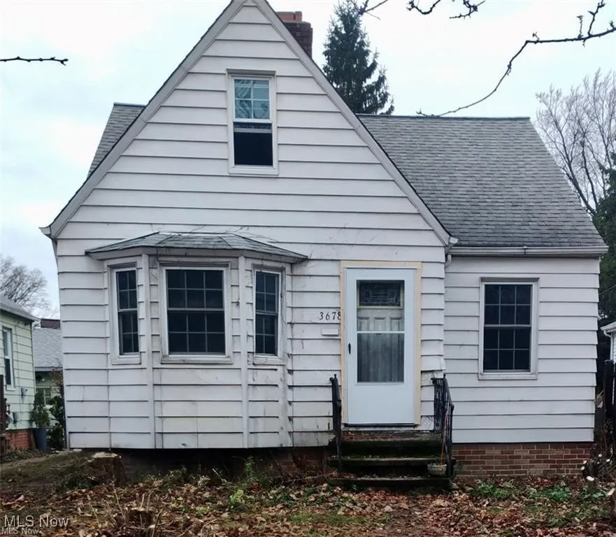 View of front of house featuring entry steps, roof with shingles, and a chimney