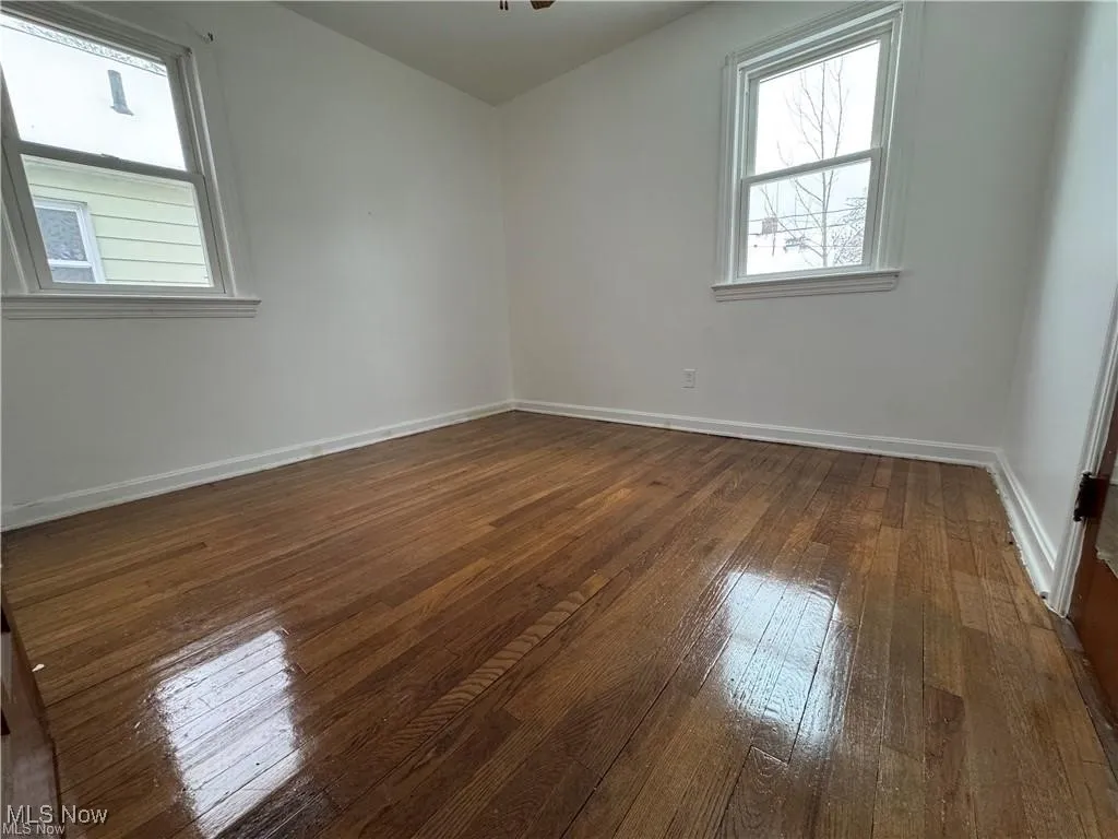 Spare room featuring dark wood-type flooring
