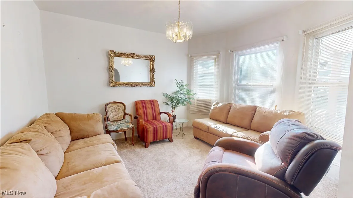 Carpeted living room with a chandelier