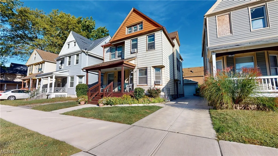 View of front of house with covered porch, a front lawn, and a residential view