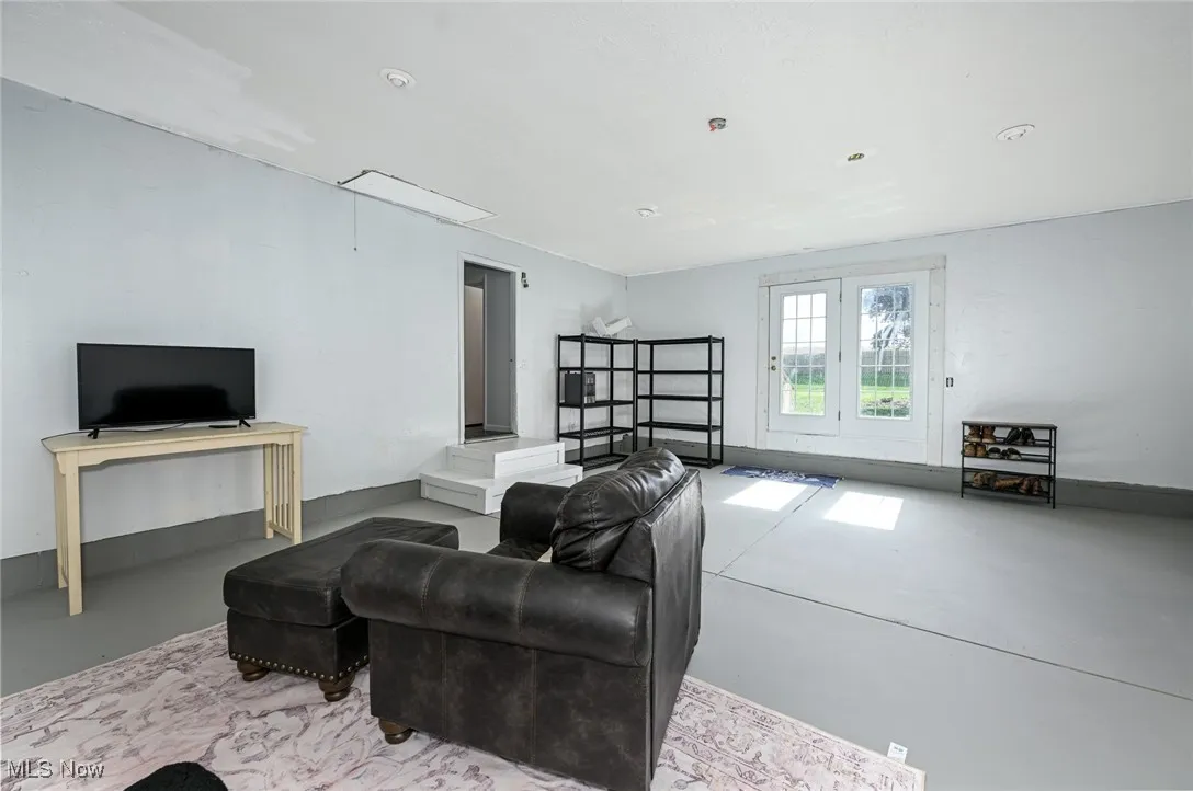 Living room featuring attic access and concrete flooring