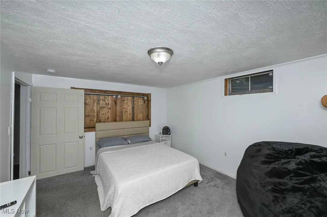Carpeted bedroom with a textured ceiling