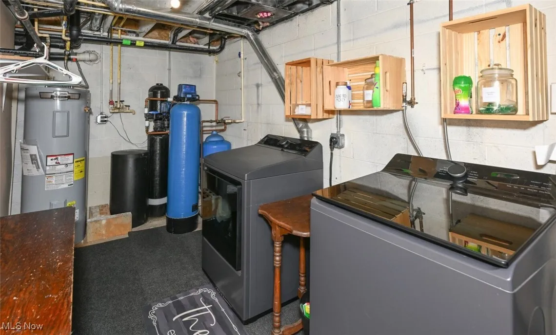 Laundry room featuring electric water heater and independent washer and dryer