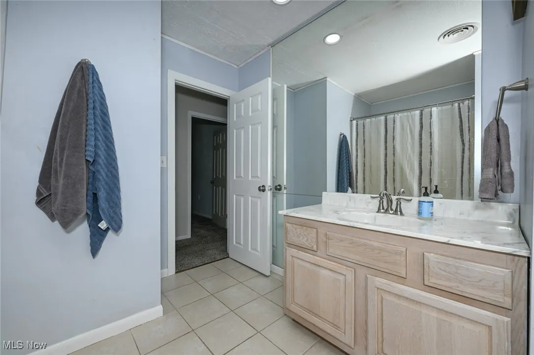 Bathroom with light tile patterned floors, vanity, recessed lighting, and a shower with shower curtain