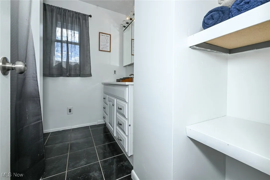 Bathroom with vanity and dark tile patterned floors