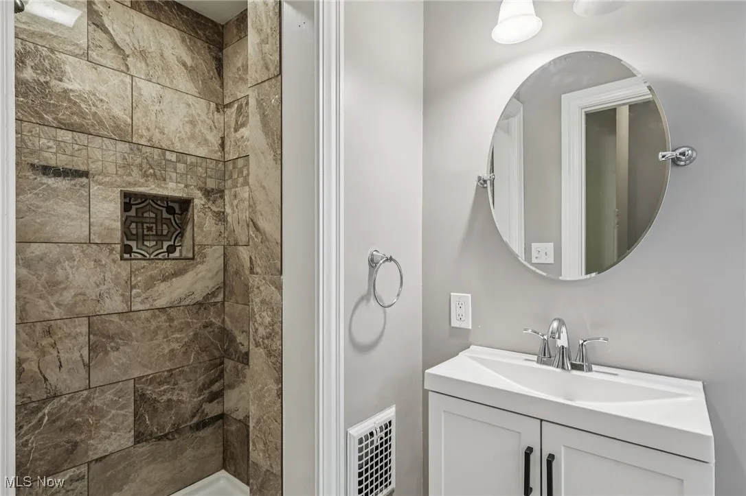 Bathroom featuring vanity and a tile shower