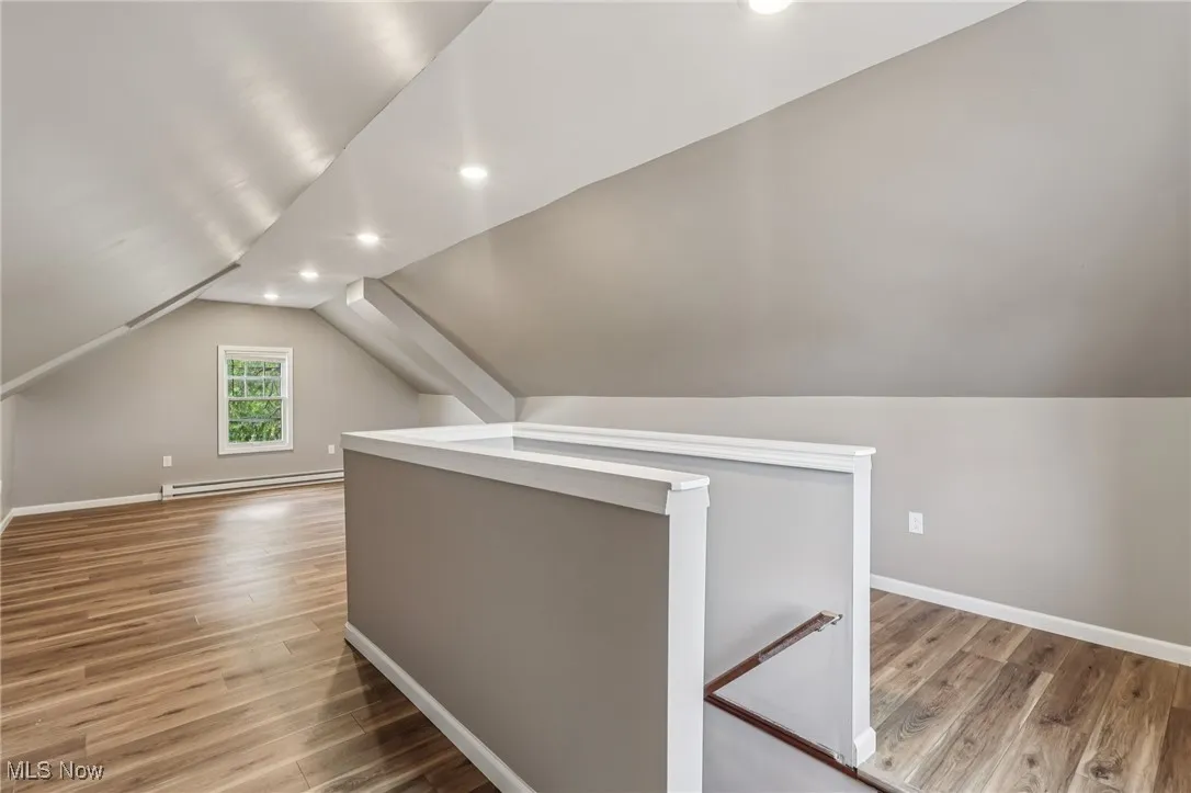 Bonus room featuring light wood finished floors, vaulted ceiling, recessed lighting, and baseboard heating