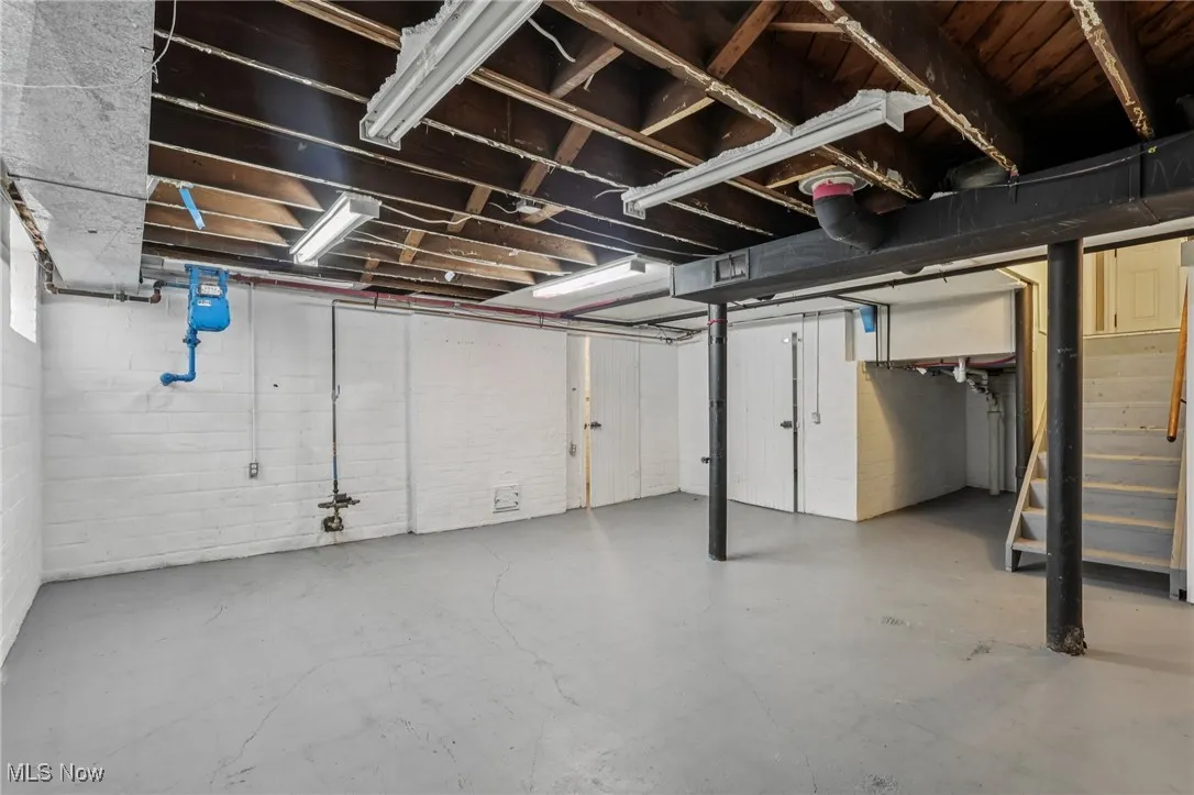 Unfinished below grade area featuring stairway