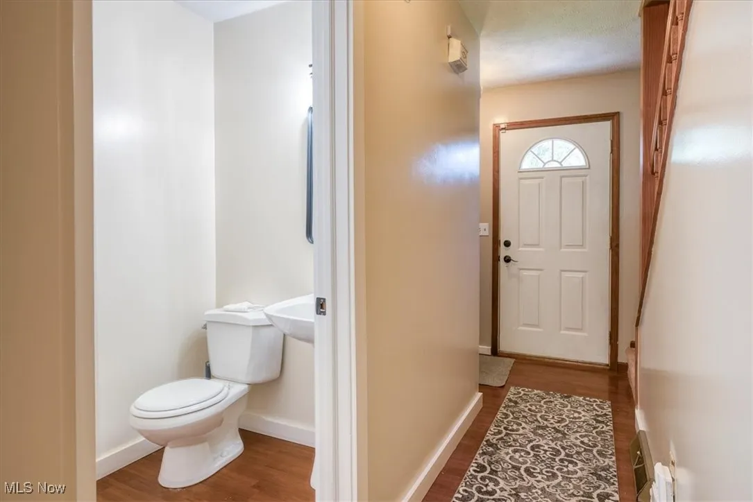 Doorway to outside featuring wood finished floors and baseboards