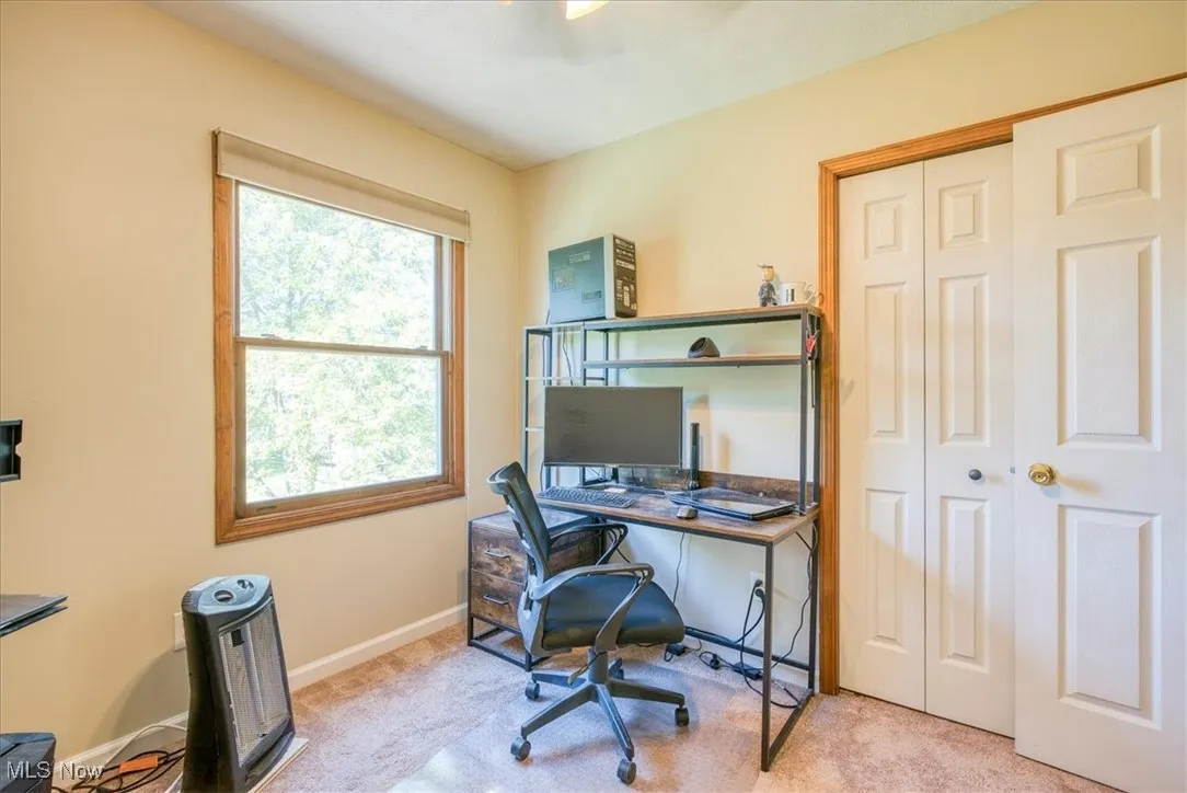 Home office featuring baseboards and light colored carpet