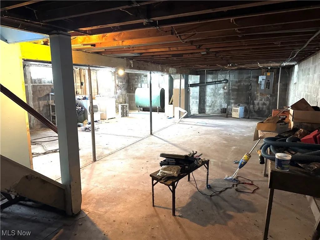 Below grade area with heating fuel, electric panel, and washer / dryer
