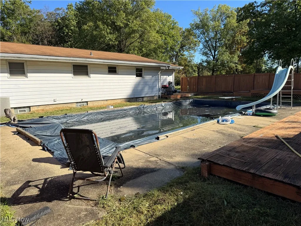 View of pool with a water slide and a patio