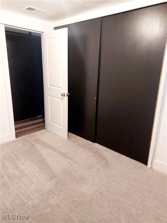 Unfurnished bedroom featuring a textured ceiling and​​‌​​​​‌​​‌‌​‌‌​​​‌‌​‌​‌​‌​​​‌​​ carpet