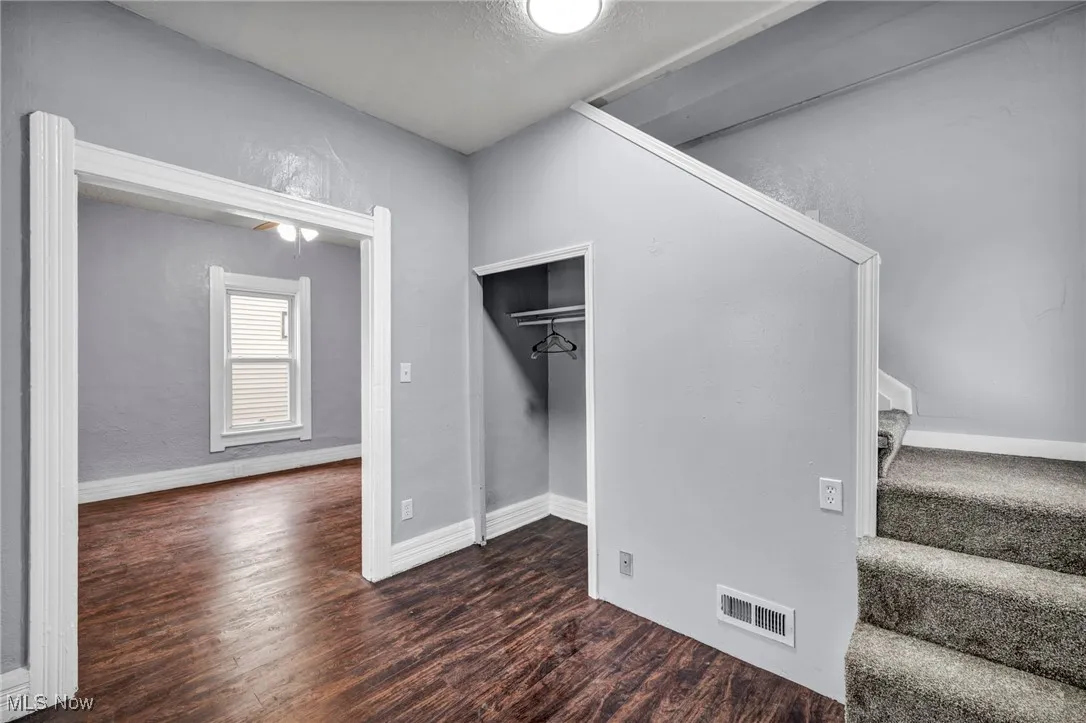 Unfurnished bedroom with dark wood-style floors and baseboards