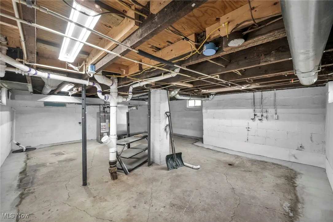 Basement featuring gas water heater and drainage system