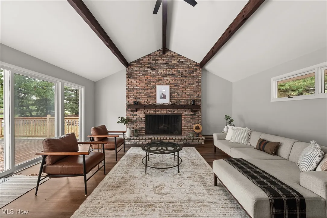 Living room featuring plenty of natural light, wood finished floors, a fireplace, and ceiling fan