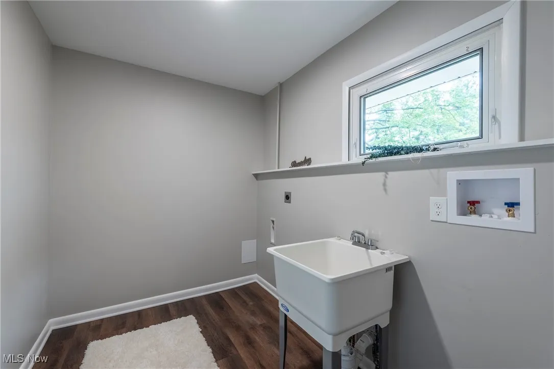 Laundry room with washer hookup, dark wood-type flooring, and electric dryer hookup
