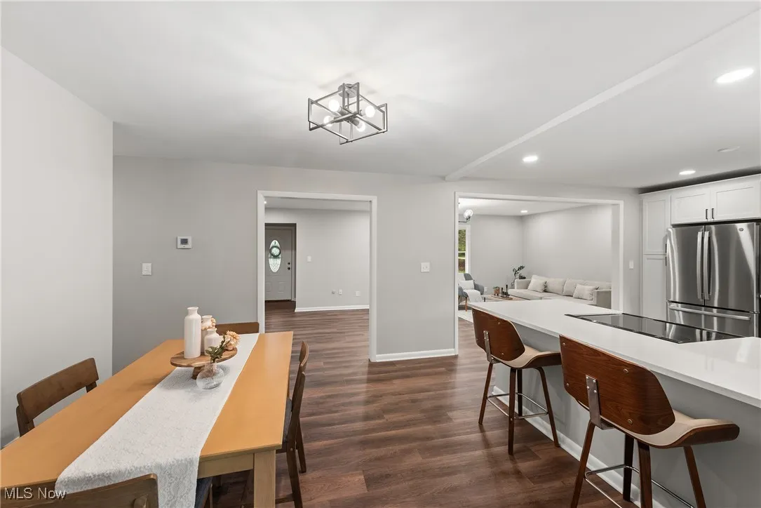 Dining room featuring dark wood-type flooring, recessed lighting, and a chandelier