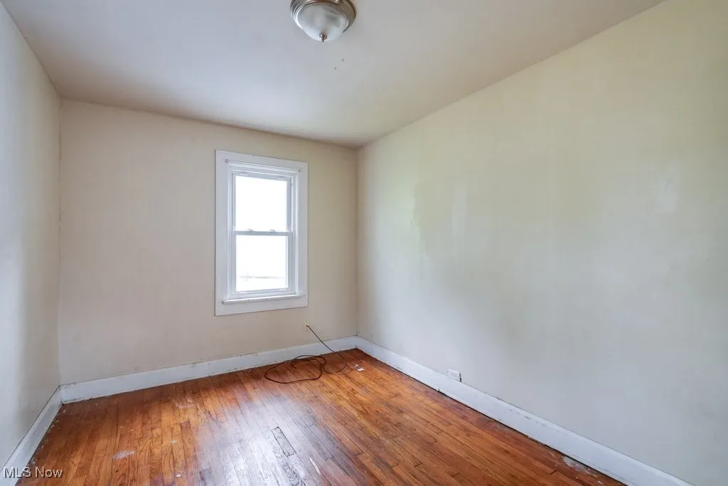 Empty room with baseboards and hardwood / wood-style floors