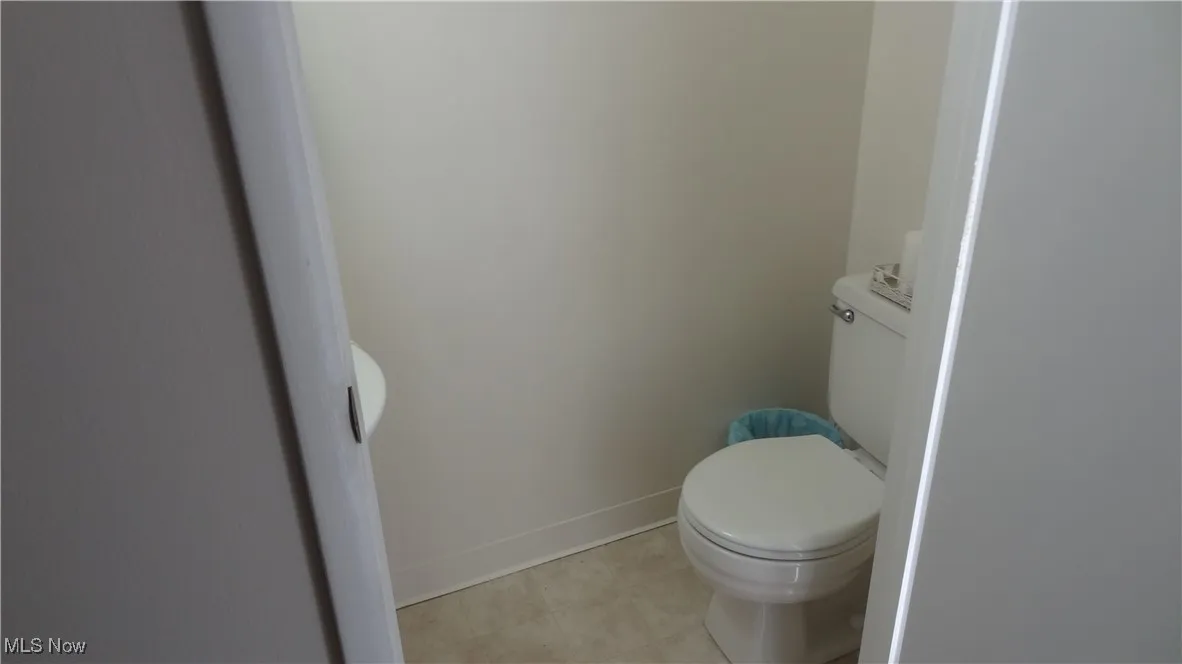 Bathroom featuring toilet and light tile patterned flooring