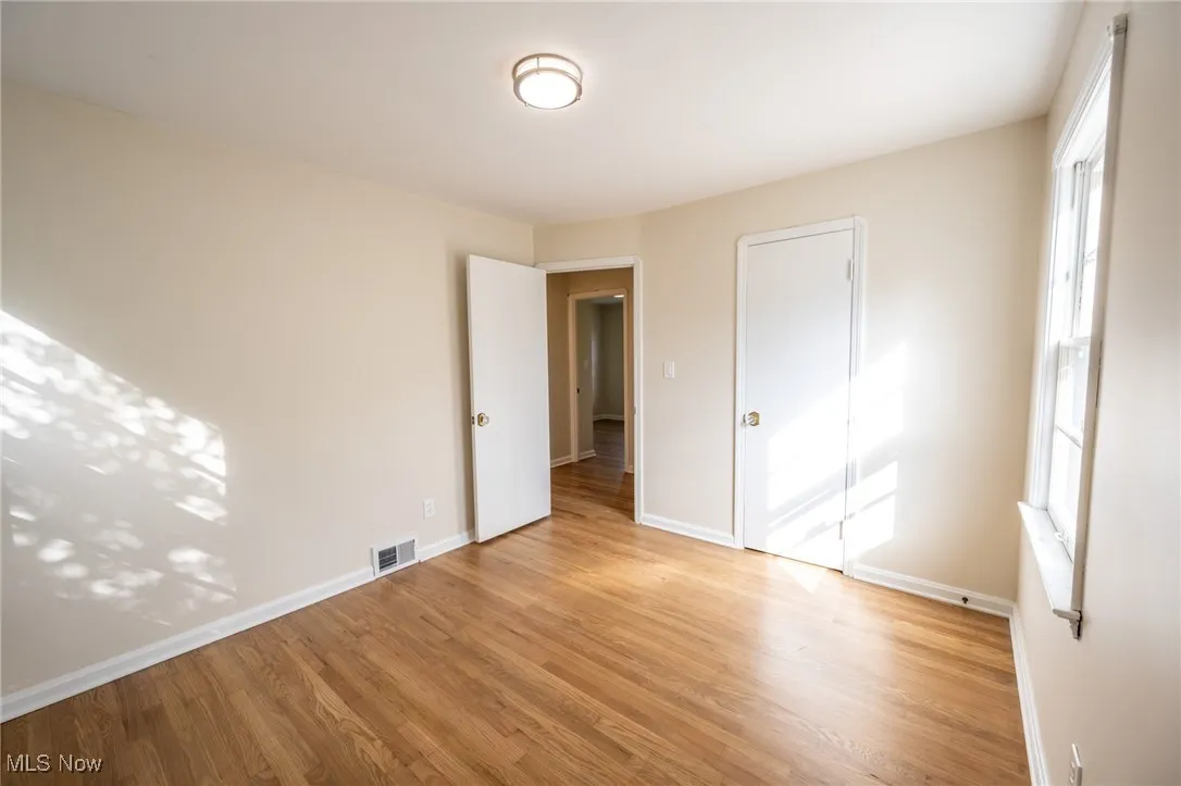 Unfurnished bedroom featuring light wood finished floors and baseboards
