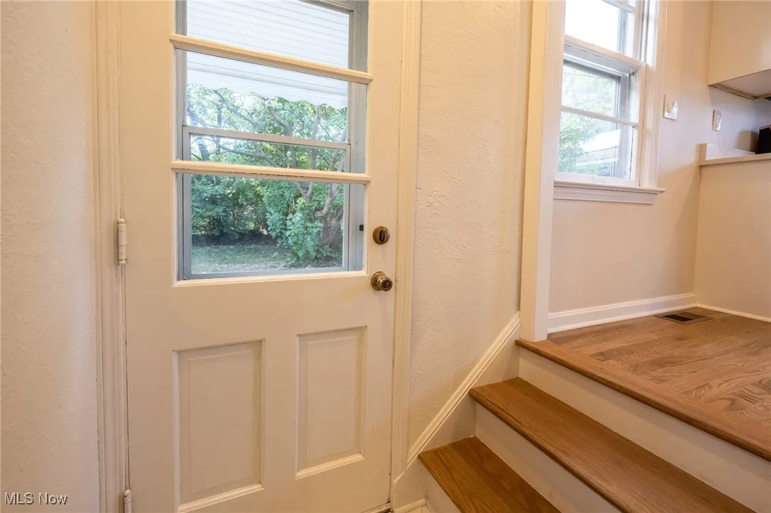 Entryway with a textured wall and baseboards