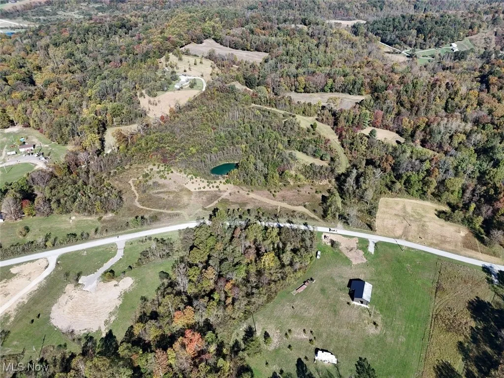Aerial view of property's location with a heavily wooded area