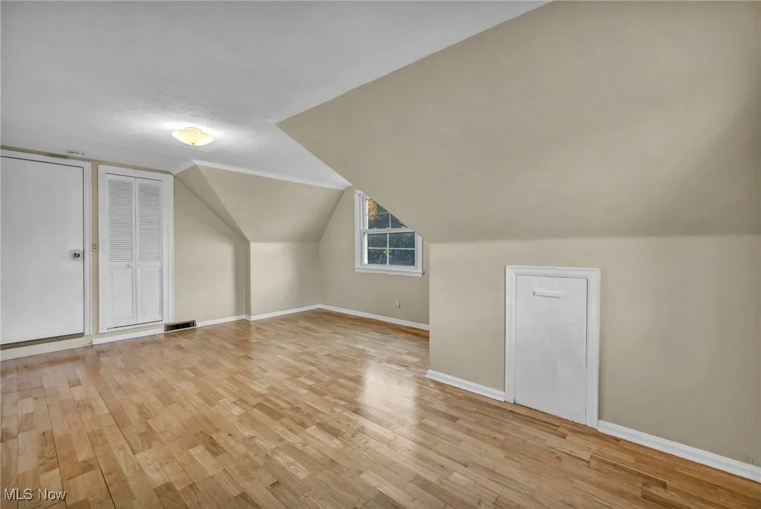 Additional living space with lofted ceiling and light wood-style flooring