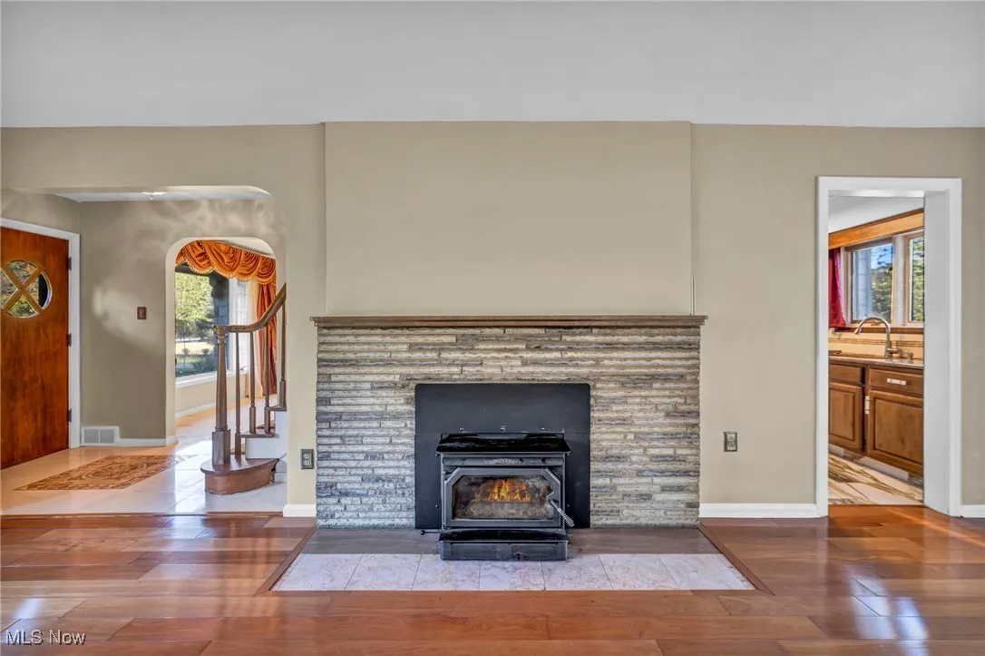 Detailed view of wood finished floors, a wood stove, and arched walkways