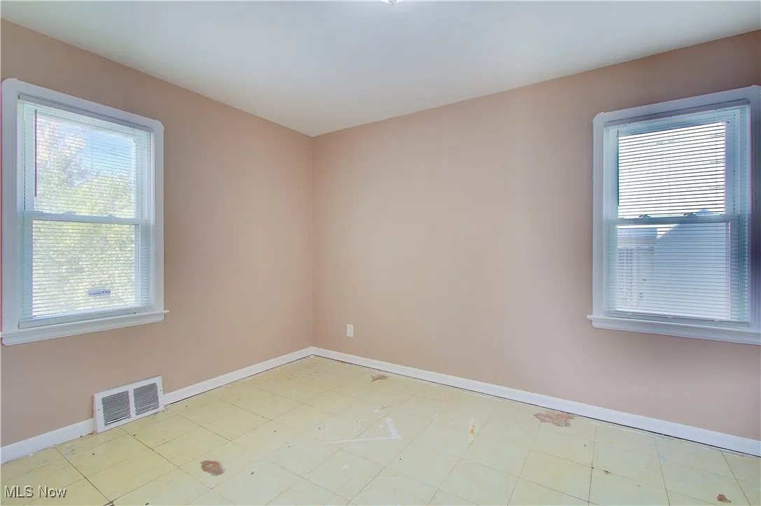 Spare room featuring baseboards and light floors