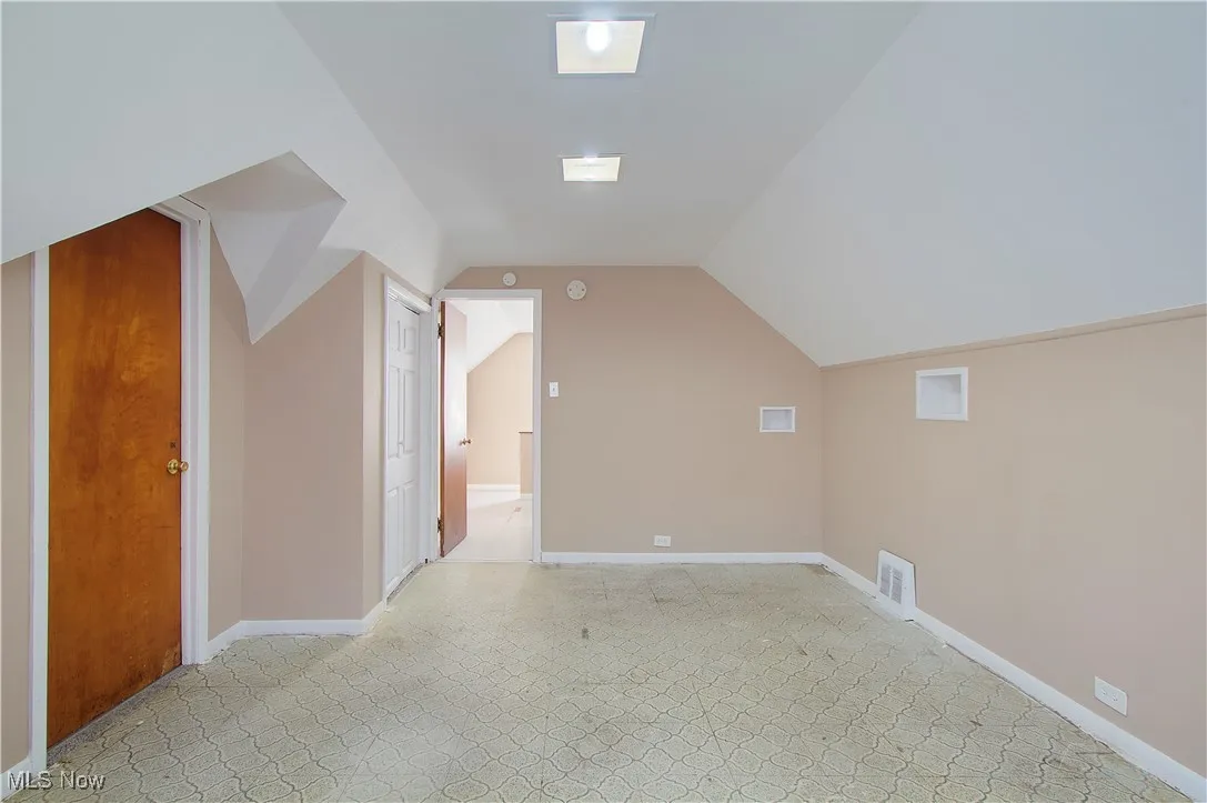 Bonus room featuring vaulted ceiling and baseboards