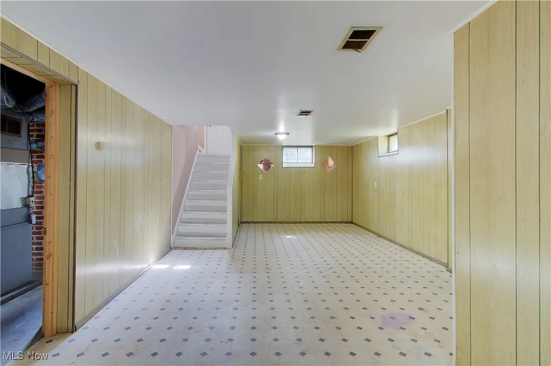 Basement featuring wood walls and stairway