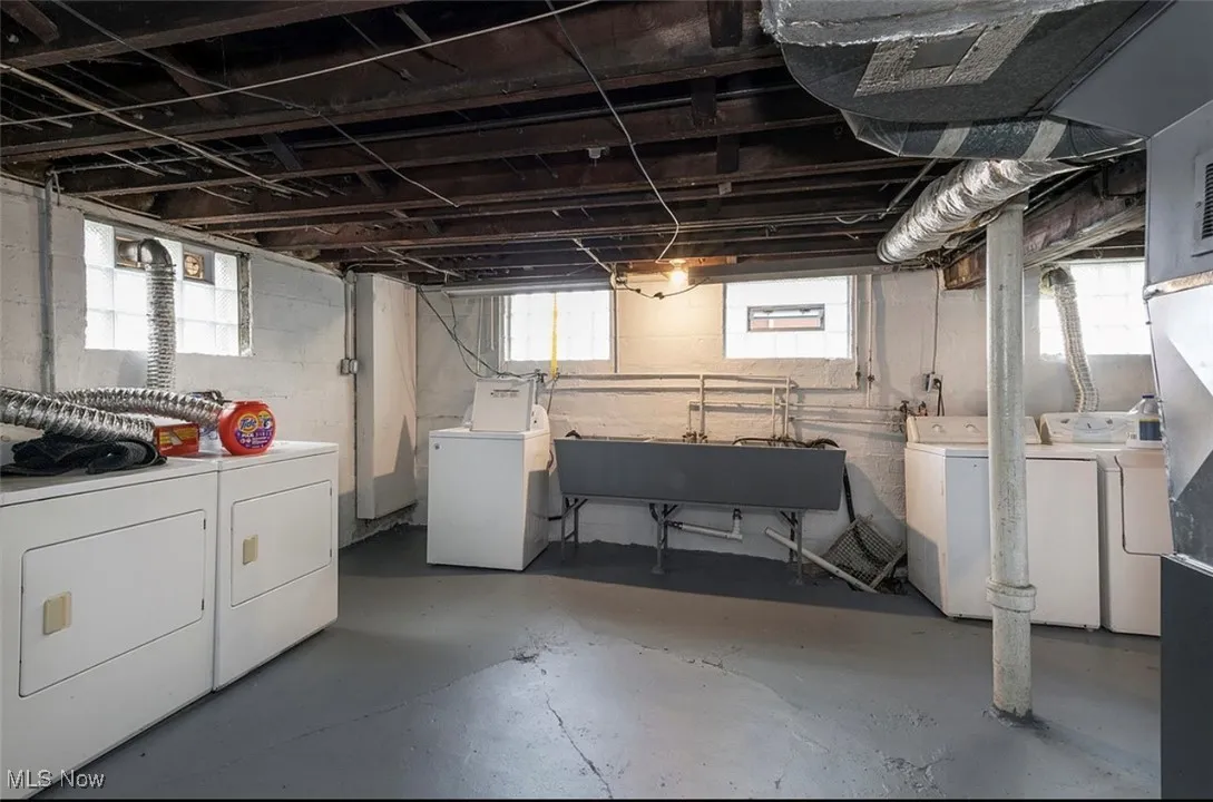 Basement with washing machine and clothes dryer and a sink