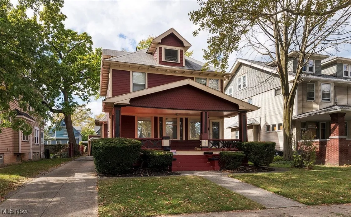 Traditional style home with covered porch and a front lawn