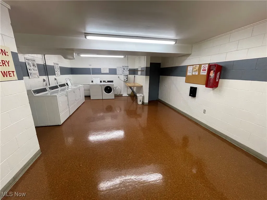 Kitchen with washer and clothes dryer and white cabinetry